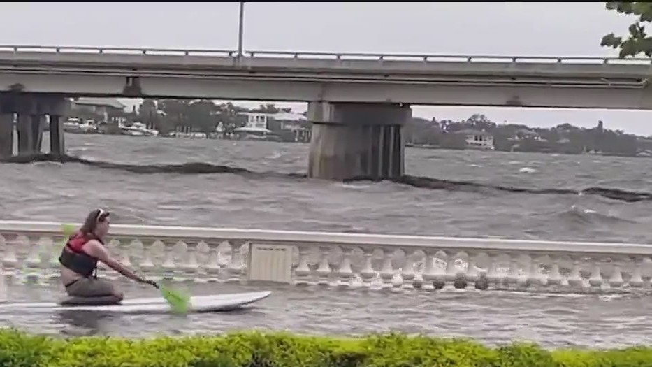 Man uses paddle board in Hurricane Idalia